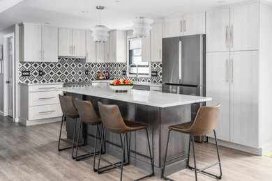 Inspiration for a mid-sized modern l-shaped eat-in kitchen in Boston with an undermount sink, flat-panel cabinets, white cabinets, quartz benchtops, multi-coloured splashback, ceramic splashback, stainless steel appliances, laminate floors, with island, beige floor and white benchtop.