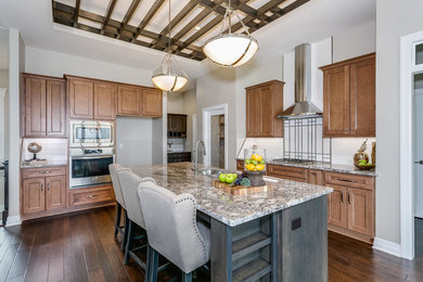 Example of a mid-sized transitional single-wall dark wood floor and brown floor enclosed kitchen design in Wichita with an undermount sink, dark wood cabinets, white backsplash, porcelain backsplash, shaker cabinets, granite countertops, stainless steel appliances, an island and multicolored countertops