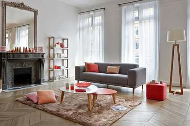 Cette image montre un grand salon design ouvert avec un mur blanc, parquet clair, une cheminée standard, un manteau de cheminée en pierre, aucun téléviseur et éclairage.