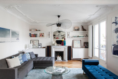 Large contemporary formal open concept living room in Paris with white walls, light hardwood floors, a standard fireplace and a stone fireplace surround.