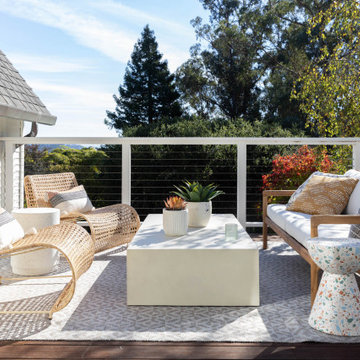 Outdoor Balcony with White Railing, Waterfall Coffee Table, and Wicker Chairs