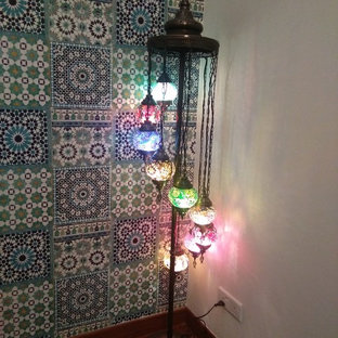 Mittelgroßes, Offenes Mediterranes Wohnzimmer mit bunten Wänden, Laminat, Wand-TV und buntem Boden in Sonstige