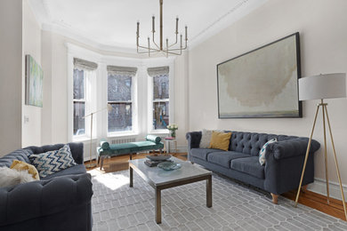 Example of a mid-sized eclectic enclosed medium tone wood floor family room design with beige walls, a standard fireplace and a wall-mounted tv