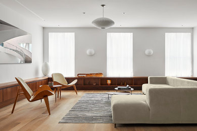Inspiration for a contemporary open concept living room in Other with white walls, light hardwood floors and brown floor.