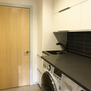 Ejemplo de lavadero multiusos y lineal, moderno, pequeño, con fregadero bajoencimera, armarios con paneles lisos, puertas de armario blancas, encimera de cuarzo compacto, paredes grises, suelo de baldosas de porcelana y lavadora y secadora juntas