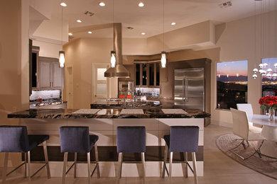 This is an example of a large contemporary u-shaped open plan kitchen in Las Vegas with flat-panel cabinets, medium wood cabinets, white splashback, stainless steel appliances, ceramic floors and with island.