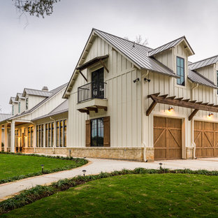 Zweistöckiges, Beigefarbenes, Großes Country Einfamilienhaus mit Satteldach, Blechdach und Faserzement-Fassade in Houston