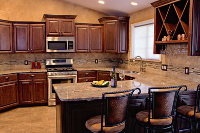 Inspiration for a mid-sized transitional u-shaped ceramic tile eat-in kitchen remodel in Seattle with a double-bowl sink, raised-panel cabinets, dark wood cabinets, granite countertops, beige backsplash, stone tile backsplash, stainless steel appliances and no island