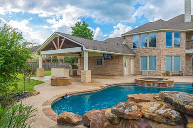 Large trendy backyard concrete paver patio kitchen photo in Houston with a roof extension
