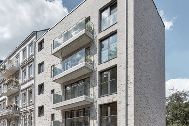 Großes, Dreistöckiges Modernes Wohnung mit Backsteinfassade, beiger Fassadenfarbe, Flachdach und Blechdach in Hamburg