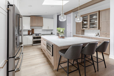 Example of a transitional l-shaped enclosed kitchen design in Chicago with quartz countertops and an island