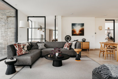 Inspiration for a large contemporary open plan living room in Devon with white walls and beige floors.