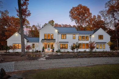 Country white two-story board and batten and clapboard exterior home photo in Philadelphia with a metal roof and a black roof
