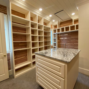 Immagine di una grande cabina armadio unisex contemporanea con ante bianche, moquette, pavimento grigio, soffitto in perlinato e ante con bugna sagomata