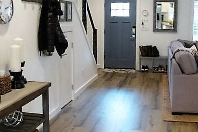 Photo of a mid-sized traditional front door in Portland with white walls, laminate floors, a single front door, a blue front door and brown floor.