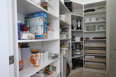 This is an example of a mid-sized modern u-shaped kitchen pantry in Vancouver with white cabinets, no island and light hardwood floors.