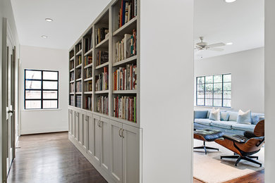 Inspiration for a timeless medium tone wood floor and brown floor family room remodel in Houston with white walls