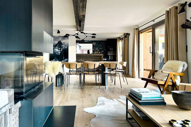 Cette photo montre un salon montagne de taille moyenne et ouvert avec un mur blanc, parquet clair, un poêle à bois, un manteau de cheminée en métal, aucun téléviseur, un sol beige et poutres apparentes.