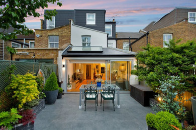 This is an example of a medium sized contemporary grey and brown enclosed living room in London with white walls, light hardwood flooring, no fireplace, a freestanding tv, beige floors, a coffered ceiling, brick walls and feature lighting.