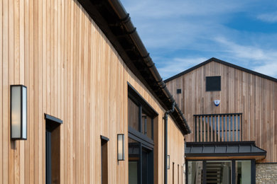 Photo of a large modern two floor house exterior in Oxfordshire with wood cladding and board and batten cladding.