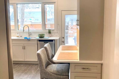 Inspiration for a mid-sized transitional u-shaped vinyl floor and gray floor enclosed kitchen remodel in Other with an undermount sink, shaker cabinets, beige cabinets, quartz countertops, white backsplash, ceramic backsplash, stainless steel appliances and white countertops