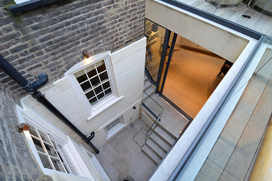 Photo of a contemporary courtyard patio in London with natural stone pavers.