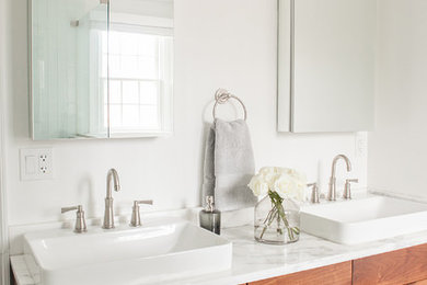 Example of a minimalist master ceramic tile and black floor bathroom design in New York with flat-panel cabinets, medium tone wood cabinets, white walls and granite countertops