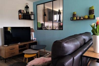 Cette image montre un salon urbain ouvert avec un mur bleu et un téléviseur indépendant.