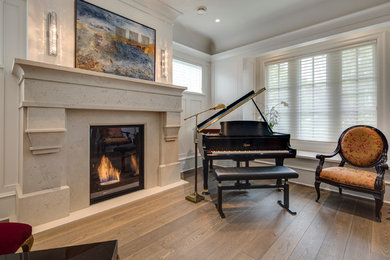 Photo of an arts and crafts enclosed living room in Vancouver with a music area, light hardwood floors, a standard fireplace and a stone fireplace surround.