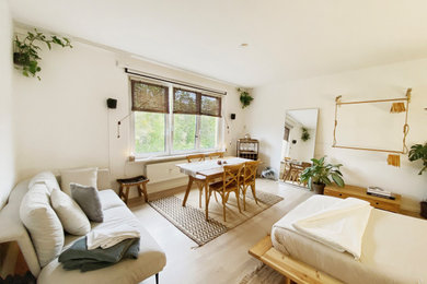 Kleines Mediterranes Schlafzimmer ohne Kamin, im Loft-Style mit weißer Wandfarbe, Laminat und beigem Boden in Berlin