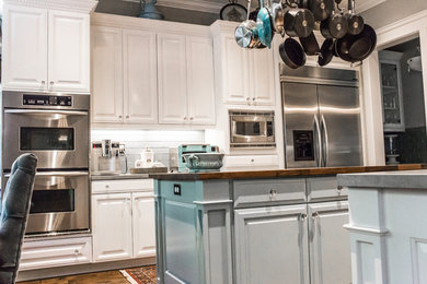 Open concept kitchen - large transitional u-shaped dark wood floor and brown floor open concept kitchen idea in San Francisco with an undermount sink, raised-panel cabinets, white cabinets, concrete countertops, gray backsplash, subway tile backsplash, stainless steel appliances and a peninsula