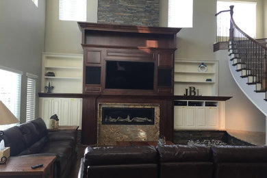 Inspiration for a mid-sized timeless open concept carpeted living room remodel in Denver with a ribbon fireplace, a wood fireplace surround, a concealed tv and beige walls