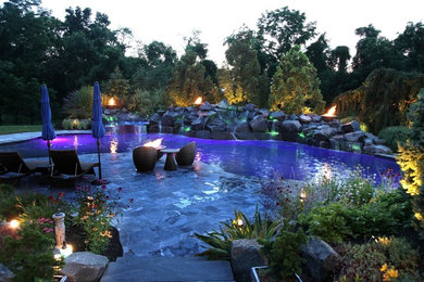 Large minimalist backyard stone pool photo in Philadelphia