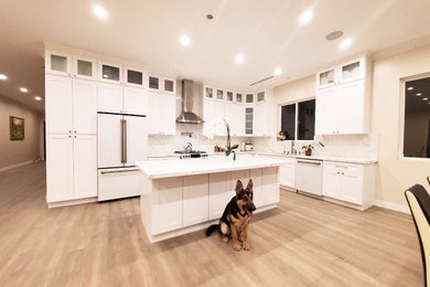 Mid-sized trendy l-shaped eat-in kitchen photo in Los Angeles with shaker cabinets, quartz countertops, quartz backsplash and an island