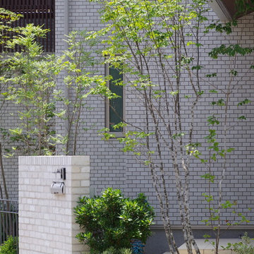 白いレンガとグレーのアイアンフェンスの外構
