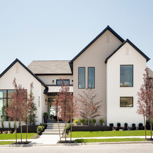 Создайте стильный интерьер: большой, разноцветный, двухэтажный фасад частного дома в стиле современная классика с комбинированной облицовкой, двускатной крышей и крышей из смешанных материалов - последний тренд