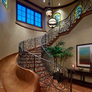 Photo of a large mediterranean wood curved metal railing staircase in Orlando with tiled risers.