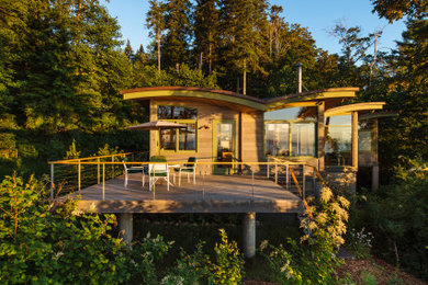 Example of a mid-sized trendy gray one-story wood house exterior design in Vancouver with a mixed material roof