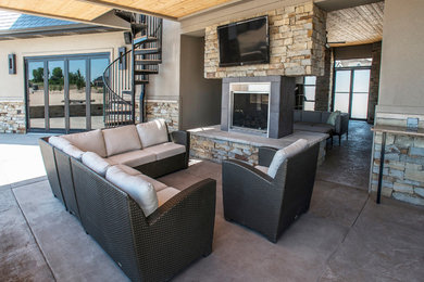 Inspiration for a large contemporary backyard stone patio kitchen remodel in Omaha with a roof extension