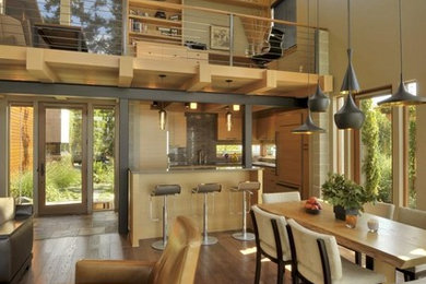 Mid-sized trendy open concept medium tone wood floor living room photo in Seattle with gray walls and a hanging fireplace