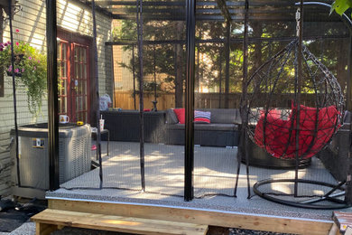 Ejemplo de terraza planta baja minimalista grande en patio trasero con brasero, toldo y barandilla de metal