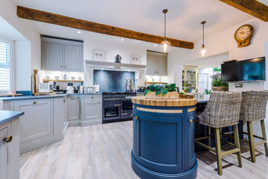 Large traditional kitchen in Manchester with a belfast sink, shaker cabinets and an island.