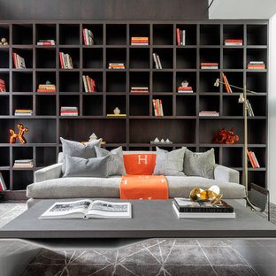 Bild på ett funkis vardagsrum, med ett bibliotek, vita väggar, heltäckningsmatta och grått golv