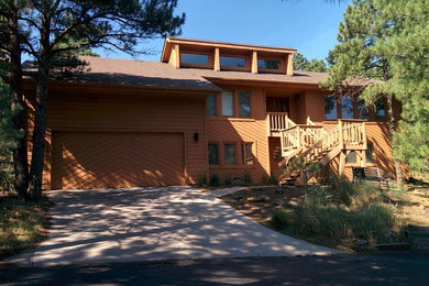 Large mountain style two-story wood exterior home photo in Other
