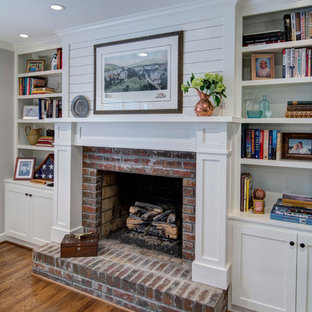 Klassisches Hauptschlafzimmer mit grauer Wandfarbe, braunem Holzboden, Kamin und Kaminumrandung aus Backstein in Atlanta