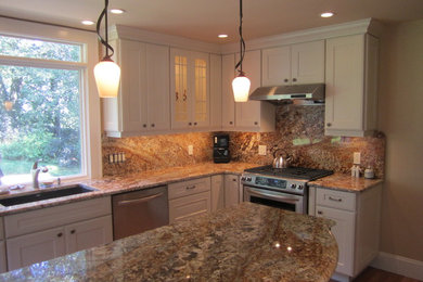 Inspiration for a mid-sized timeless l-shaped medium tone wood floor and brown floor open concept kitchen remodel in Boston with an undermount sink, recessed-panel cabinets, white cabinets, granite countertops, brown backsplash, stone slab backsplash, stainless steel appliances and an island