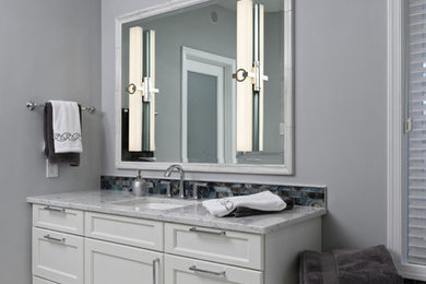 Example of a large transitional master white tile and glass tile porcelain tile and white floor walk-in shower design in DC Metro with recessed-panel cabinets, white cabinets, an undermount tub, a one-piece toilet, gray walls, an undermount sink, quartz countertops, a hinged shower door and white countertops