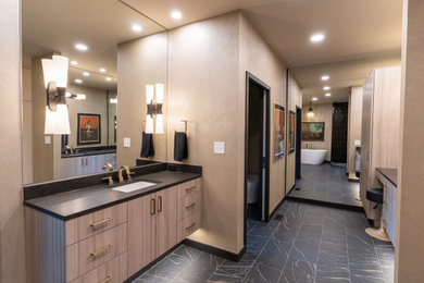 Large eclectic master black tile and porcelain tile black floor, double-sink and porcelain tile bathroom photo in Charlotte with flat-panel cabinets, beige cabinets, a one-piece toilet, beige walls, a drop-in sink, black countertops, a floating vanity and granite countertops
