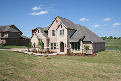 Large elegant beige two-story stone house exterior photo in Dallas