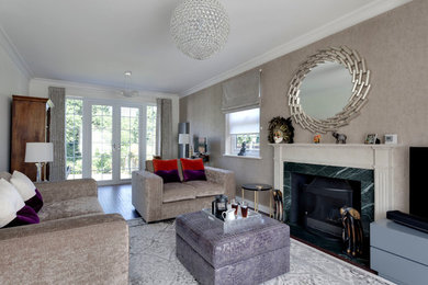 Photo of a contemporary living room in London with beige walls, medium hardwood flooring, a standard fireplace, a stone fireplace surround and a freestanding tv.